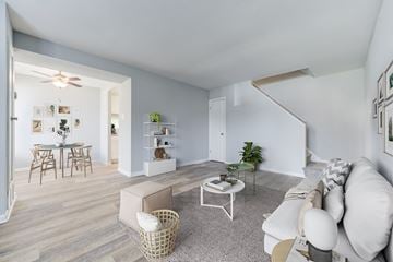 Philadelphia apartment for rent - A living room with a white couch, a coffee table, and a dining table with chairs.