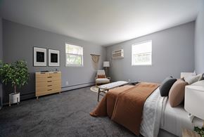 Philadelphia apartment for rent - A bedroom with a bed, chair, and plant.