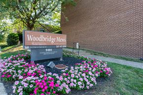 Philadelphia apartment for rent - A sign for Woodbridge Mews is surrounded by flowers.