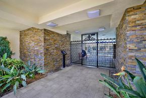 Torrance apartment for rent - the entrance to a building with a gate at Olive Tree Apartments, California