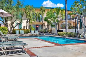 Torrance apartment for rent - a swimming pool with chairs and a building in the background at Camino de Oro Apartments, California, 90505