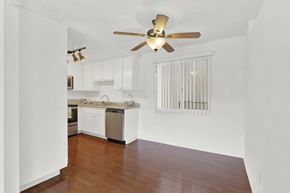 Torrance apartment for rent - an empty living room and kitchen with a ceiling fan at Casa De Oro Apartments, Torrance