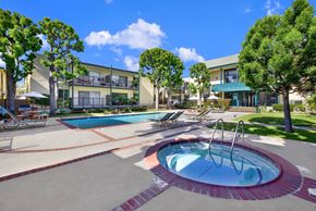 Torrance apartment for rent - a jacuzzi and swimming pool in front of an apartment building at Copa Ladeene Apartments, Torrance California