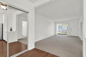 Torrance apartment for rent - a living room with white walls and a mirrored door at Olive Tree Apartments, Torrance, 90503