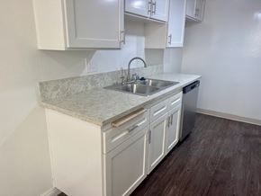 Torrance apartment for rent - A kitchen with white cabinets and a marble countertop. at Copa Triana Apartments, Torrance