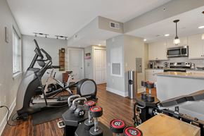Fayetteville townhouse for rent - A home gym with a treadmill, weights, and exercise equipment.