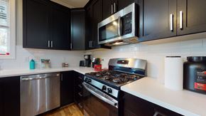 Raleigh townhouse for rent - A modern kitchen with black cabinets and stainless steel appliances.