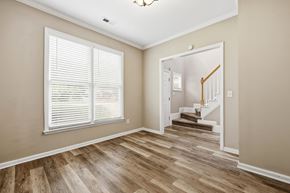 Wake Forest apartment for rent - A room with wooden floors and a staircase leading to another room.
