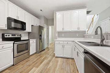 Wake Forest apartment for rent - A kitchen with white cabinets and stainless steel appliances.