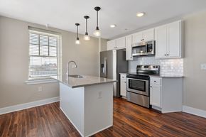 Fayetteville townhouse for rent - A kitchen with a stove top oven and a microwave above it.