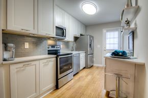 Raleigh condo for rent - A kitchen with white cabinets and stainless steel appliances.