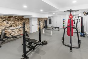 Philadelphia apartment for rent - a gym with weights and other equipment and a stone wall