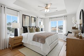 Lawrenceville townhouse for rent - A bedroom with a large bed and a ceiling fan.