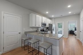 1280 Dunbar Rd apartment for rent - A kitchen with a granite countertop and bar stools.