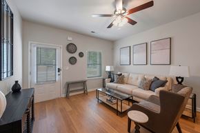 1280 Dunbar Rd apartment for rent - A living room with a white couch, a coffee table, and a ceiling fan.
