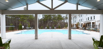 Lawrenceville townhouse for rent - A large covered patio with a pool and green chairs.