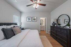 Warner Robins apartment for rent - A bedroom with a large bed and a dresser with a mirror.