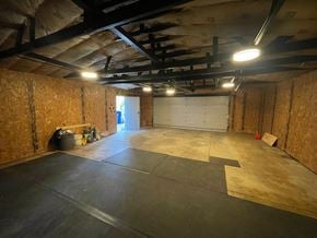 North Chicago house for rent - A large empty room with a black floor and walls covered in insulation.