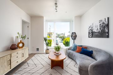 San Francisco apartment for rent - A living room with a grey couch, a wooden coffee table, and a painting on the wall.