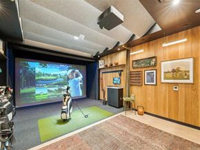 Menlo Park apartment for rent - A room with a golf simulator and a TV screen showing a golf game.