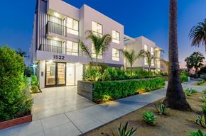 Los Angeles apartment for rent - A modern building with the number 1522 on it is surrounded by greenery.