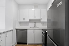 Toronto apartment for rent - A modern kitchen with white cabinets and stainless steel appliances.