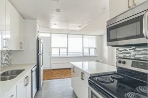 Toronto apartment for rent - an empty kitchen with white cabinets and stainless steel appliances