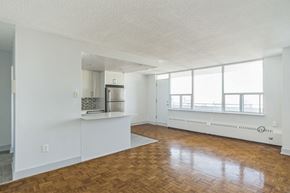 Toronto apartment for rent - an empty living room and kitchen with wood flooring and a large window