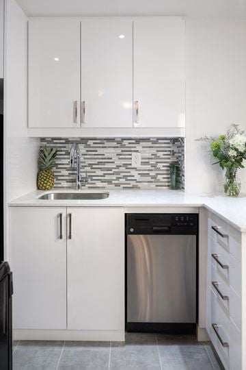 Toronto apartment for rent - A modern kitchen with a stainless steel dishwasher and white cabinets.