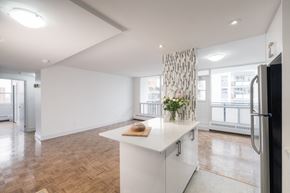 Toronto apartment for rent - a white kitchen with a white counter top and a large window