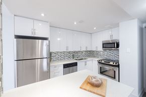 Toronto apartment for rent - a kitchen with white cabinets and stainless steel appliances