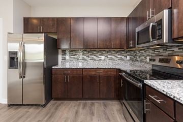 Des Moines apartment for rent - A kitchen with a stainless steel refrigerator and wooden cabinets.