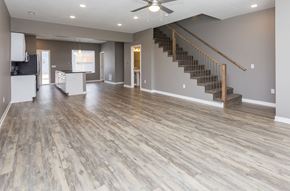 Des Moines apartment for rent - an empty living room with a hard wood floor and a staircase at 5Fifty5, Des Moines, IA 50309  