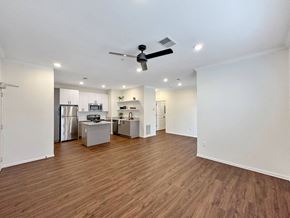 West Des Moines apartment for rent - an empty living room with a kitchen and a ceiling fan at 92West, Iowa