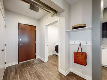 A room with a brown door and a brown bag hanging on the wall.