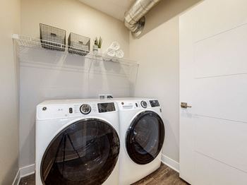 Two white front load washing machines in a laundry room.