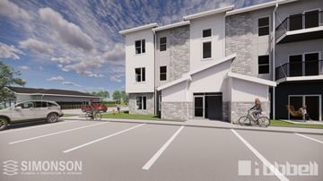 Ankeny townhouse for rent - A modern apartment complex with a parking lot in front.