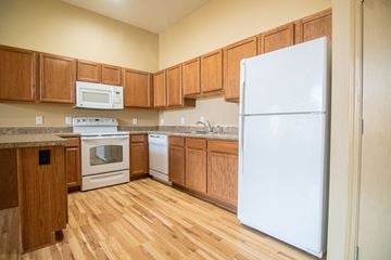 Johnston apartment for rent - A kitchen with wooden cabinets and a white refrigerator.