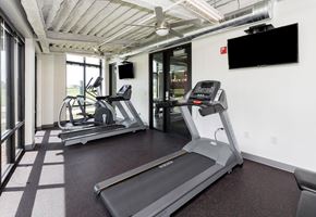 Des Moines apartment for rent - A gym with treadmills and a television mounted on the wall. at Eagle View Lofts, Iowa