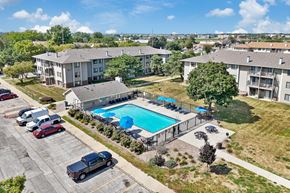 Urbandale apartment for rent - A swimming pool surrounded by apartment buildings and cars.