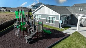 Bondurant apartment for rent - A playground with a green slide and a grey house in the background.