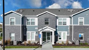 Bondurant apartment for rent - The front of a building with a blue sign on the right side.
