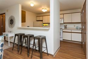 Des Moines apartment for rent - a living room with three bar stools and a kitchen at Rosemont Place Apartments, Des Moines, 50320
