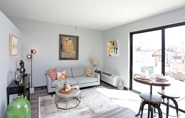 Des Moines apartment for rent - A living room with a couch, a table, and a painting on the wall.
