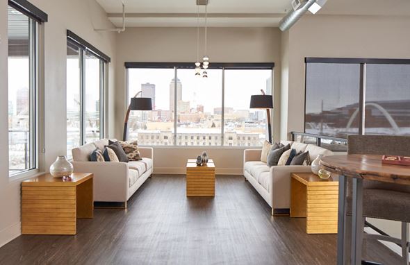 Des Moines apartment for rent - a living room with white couches and a view of the city at Velocity Apartments, Des Moines
