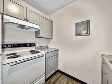 Indianola apartment for rent - A small kitchen with a white stove and a white oven.