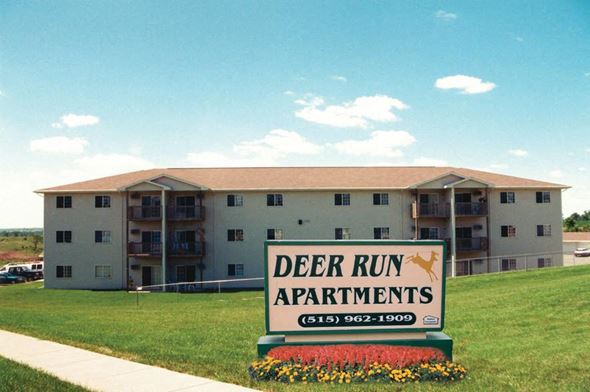 Indianola apartment for rent - A sign for Deer Run Apartments is in front of a building.