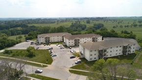 Indianola apartment for rent - A large white building with a parking lot in front of it.