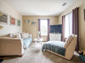 Newton apartment for rent - A living room with a couch, chair, and a small table at Hunters Run Apartments, Iowa, 50208