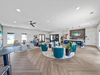 A large living room with blue chairs and a dining area